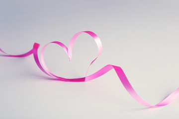 Ribbon shaped as heart on gray background