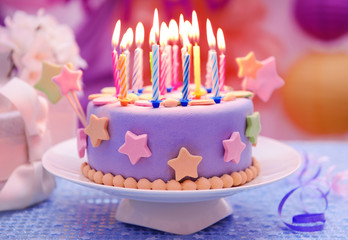 Delicious birthday cake on table on bright background