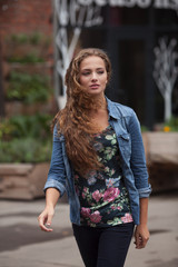 Beautiful young girl with curly hair in denim shirt