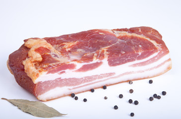 piece of bacon, bell pepper and bay leaf on a light background