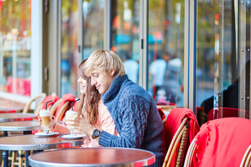 Dating couple drinking coffee in a Parisian cafe