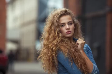 Papier Peint photo Salon de coiffure Beautiful young girl with thick long curly hair outdoors