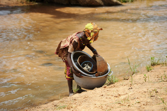 Ni&ntilde;a lavando en el r&iacute;o