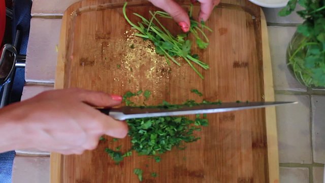 Woman chopping cilantro with a knife