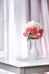 Fototapeta premium Beautiful flowers in vase with light from window