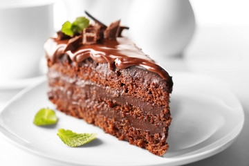 Delicious chocolate cake on plate on table on light background