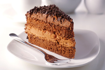 Delicious chocolate cake on plate on table on light background