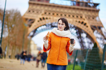 Fototapeta na wymiar Young woman in Paris with croissant and coffee