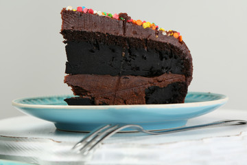 Chocolate cake with colorful sweet powder on table close-up