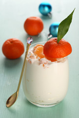 Tasty milk dessert with fresh tangerine pieces in glass,