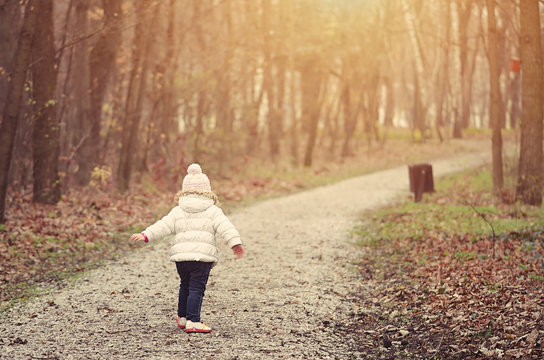 Little girl run in the autumn forest
