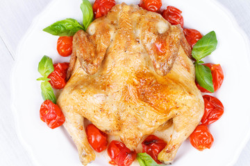 Roast chicken with tomatoes cherry, green basil and garlic