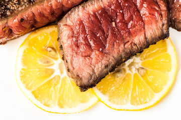 Sliced roasted meat with slices of lemon