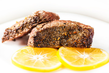 Sliced roasted meat with slices of lemon