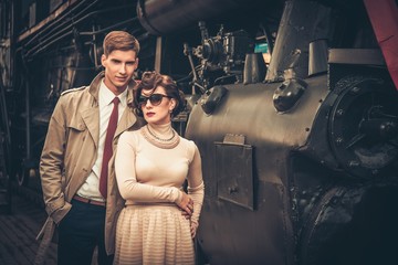 Vintage style couple near steam locomotive