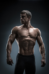 Fototapeta na wymiar Stunning muscular young men bodybuilder looking behind