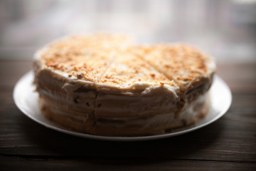 Homemade honey cake with cut piece on a table