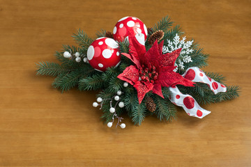 Composition from Poinsettia Plant with spruce branches on wooden