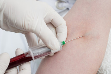 Taking a blood from the patient's arm.
