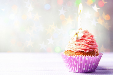 Delicious birthday cupcake on wooden table