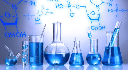 Test-tubes with blue liquid on color background