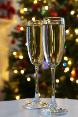 Two champagne glasses on table, on fir-tree background