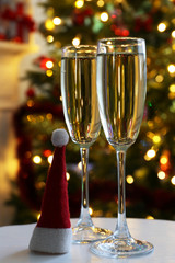 Two champagne glasses with red Santa hat