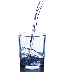 Pouring water from bottle on  glass isolated on white