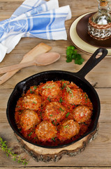 Fried meatballs with tomato sauce and spices in frying pan