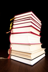 Books on a wooden table on a black background