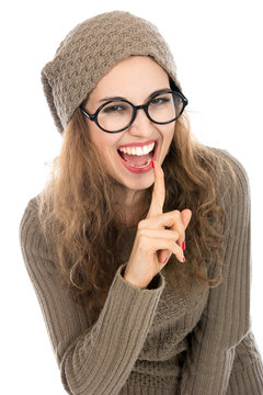 Portrait cheerful of young woman keeping finger on her lips and