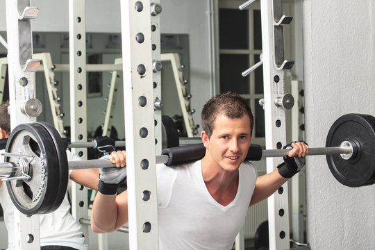 Mann beim Gewicht heben im Fitness-Studio