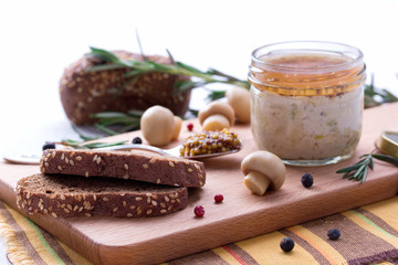 Chicken pate in jar and sliced bread with mustard