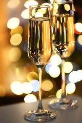Two glass with champagne on table on bright background