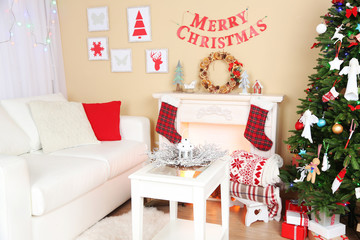 Beautiful Christmas interior with sofa, decorative fireplace