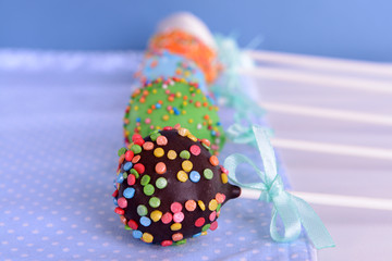 Sweet cake pops on table on blue background