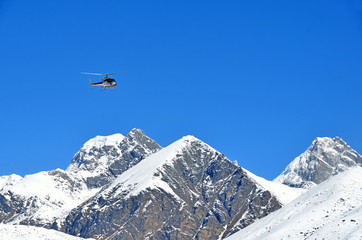 Fototapeta na wymiar Вертолет в полете над заснеженными вершинами Гималаев