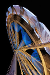 Fototapeta na wymiar Fairground ferris wheel with colorful light trails