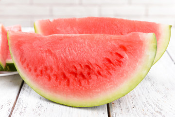 Juicy watermelon on table on brick wall background