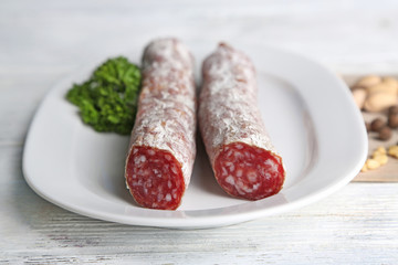 Italian salami on plate,  on wooden background