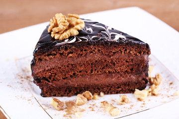 Delicious chocolate cake on plate on table close-up