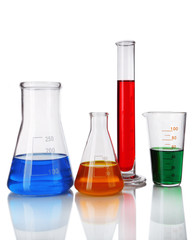 Test-tube and flasks with colorful fluid on light background