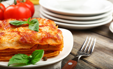 Portion of tasty lasagna on wooden table