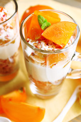 Healthy layered dessert with muesli and fruits on table
