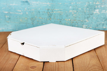 Empty cardboard pizza box on wooden table