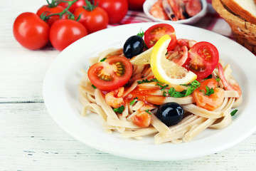 Tasty pasta with shrimps, black olives and tomato sauce