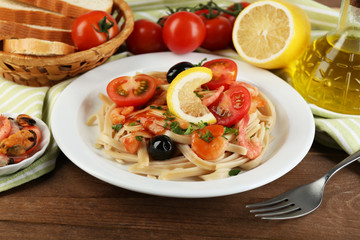 Tasty pasta with shrimps, mussels, black olives and tomato
