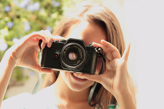 chica adolescente con c&aacute;mara antigua sacando fotos