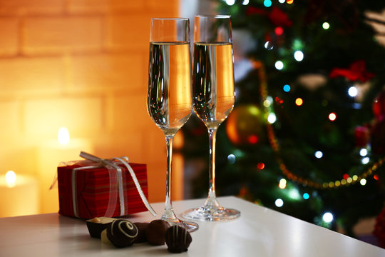 Two glass with champagne with chocolates and present box