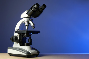 Microscope on table, on color background